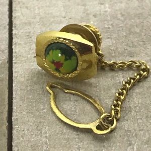 Gold tone tie tack with green, red, yellow stone